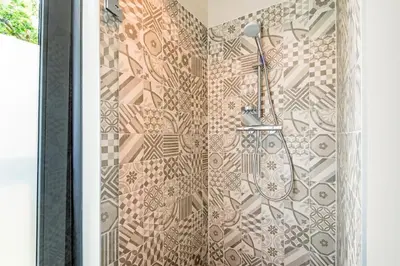 a bathroom with a shower with a tile wall at Villa Merici in Bergen