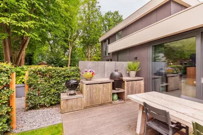 a backyard patio with a wooden table and bench at Villa Merici in Bergen
