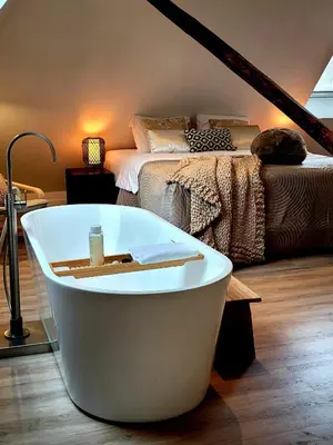 a bath tub in a room with a bed at Dream Boutique Edam Bed & Coffee in Edam