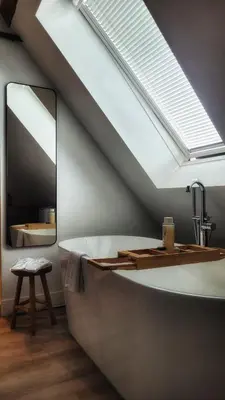 a bathroom with a bath tub and a mirror at Dream Boutique Edam Bed & Coffee in Edam