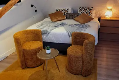 a bedroom with a bed with two chairs and a table at Dream Boutique Edam Bed & Coffee in Edam