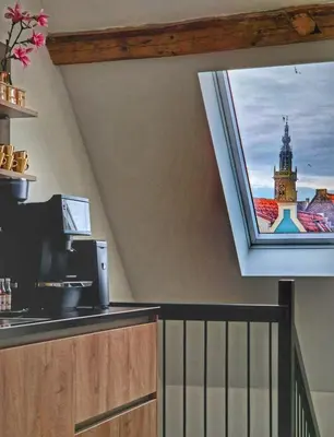 a kitchen with a window with a view of a clock tower at Dream Boutique Edam Bed & Coffee in Edam