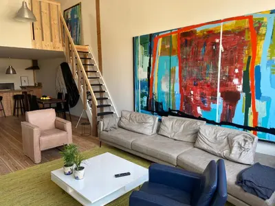 a living room with a couch and a painting on the wall at Luca’s Loft in Bergen