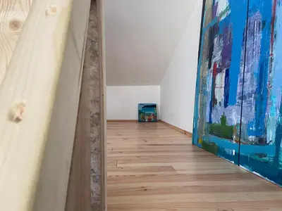 a hallway with a painting and a wooden floor at Luca’s Loft in Bergen