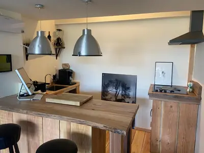 a kitchen with a wooden counter with a laptop on it at Luca’s Loft in Bergen