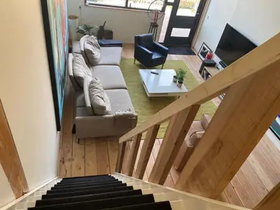 a living room with a couch and a staircase at Luca’s Loft in Bergen
