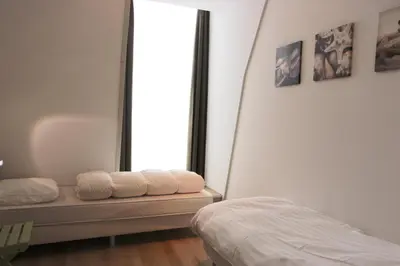 a bedroom with a mirror and a bed with towels at Heerlijke vakantiehuizen in Egmond in Egmond aan Zee