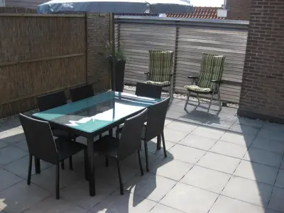 a table and chairs sitting on a patio at Heerlijke vakantiehuizen in Egmond in Egmond aan Zee