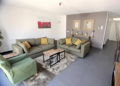 a living room with a couch and a table at Heerlijke vakantiehuizen in Egmond in Egmond aan Zee