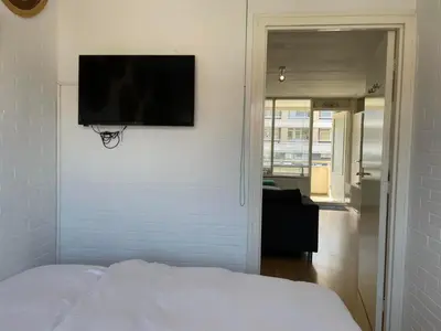 a bedroom with a flat screen tv on a wall at Heerlijke vakantiehuizen in Egmond in Egmond aan Zee