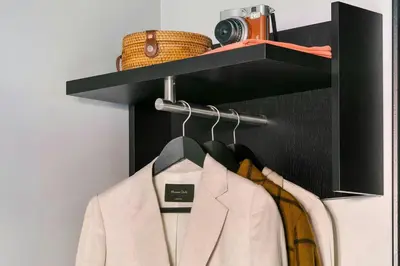 a shelf with a white jacket and a camera on it at S&A Vondel Park Hotel in Amsterdam