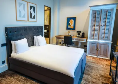 a bedroom with a large bed and a desk at S&A Vondel Park Hotel in Amsterdam