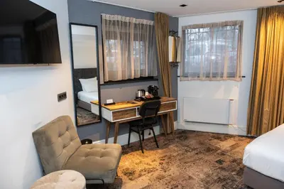 a hotel room with a desk and a bedroom at S&A Vondel Park Hotel in Amsterdam