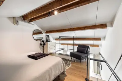 a loft bedroom with a bed and a chair at BnB Purmerland in Purmerend