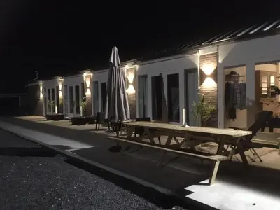 a picnic table with an umbrella next to a building at night at BnB Purmerland in Purmerend