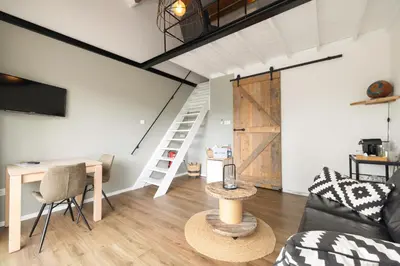 a living room with a couch and a desk and a loft at BnB Purmerland in Purmerend