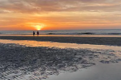 two people standing on the beach at sunset at Stop & Stay 2 in Zandvoort