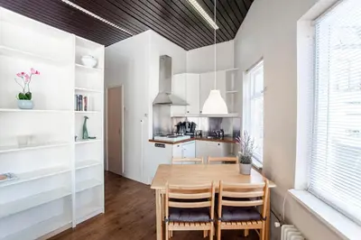 a kitchen with a wooden table and chairs at Stop & Stay 1 in Zandvoort