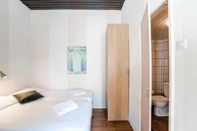 a small bedroom with a bed and a toilet at Stop & Stay 1 in Zandvoort