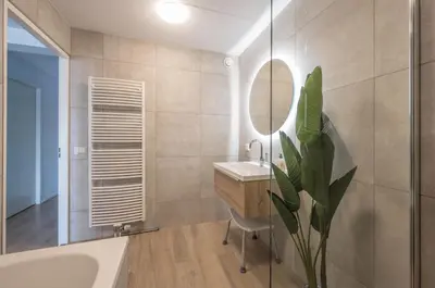 a bathroom with a tub and a sink and a mirror at Meerzicht 70 - Vakantiehuis aan het water! in Uitgeest