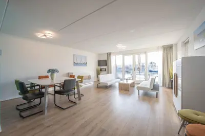 a large living room with a table and chairs at Meerzicht 70 - Vakantiehuis aan het water! in Uitgeest