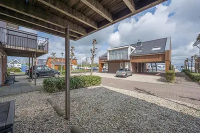 a house with a car parked in a driveway at Meerzicht 70 - Vakantiehuis aan het water! in Uitgeest