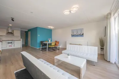 a living room with a couch and a table at Meerzicht 70 - Vakantiehuis aan het water! in Uitgeest