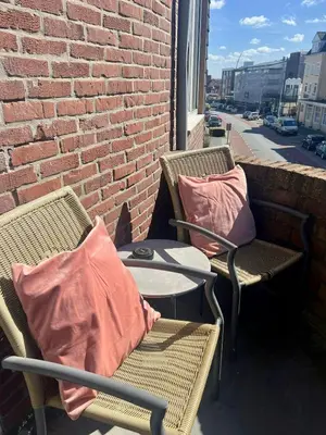 two chairs with pillows and a table on a balcony at Pure Apartment in Zandvoort