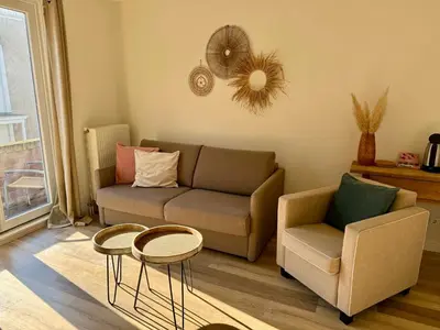 a living room with a couch and a chair and tables at Pure Apartment in Zandvoort