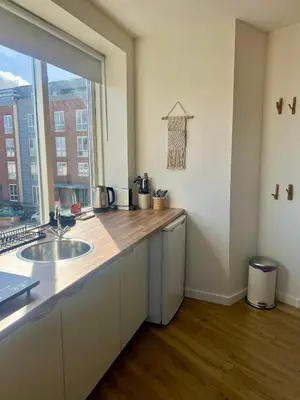 a kitchen with a sink and a large window at Pure Studio in Zandvoort