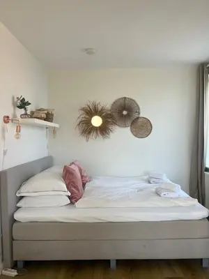 a bed in a bedroom with two hats on the wall at Pure Studio in Zandvoort
