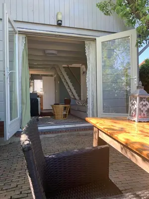 a screened in porch with a table and chairs at Lovely holiday house in Durgerdam in Amsterdam