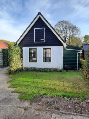 a black and white house with a yard at Bakker1 in Groet