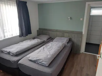 two twin beds in a room with a window at Bakker1 in Groet
