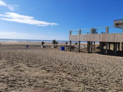a building on the beach with the ocean in the background at Bakker1 in Groet