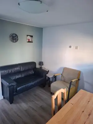 a living room with a leather couch and a chair at Bakker1 in Groet