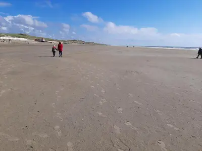 a group of people walking on the beach at Bakker1 in Groet
