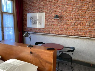 a room with a table and chairs and a brick wall at Hotel & bar Royal taste Amsterdam in Amsterdam