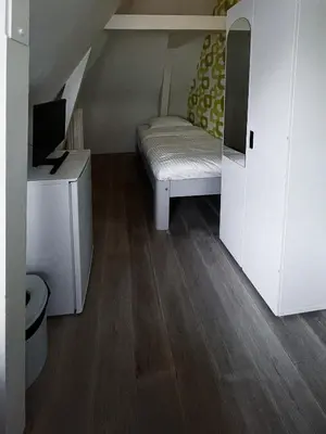 a small living room with a couch and a tv at Hotel & bar Royal taste Amsterdam in Amsterdam