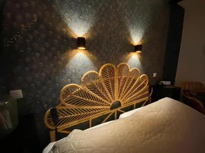 a bedroom with a bed and two chairs and a wall at Paauwze in Rijnsburg