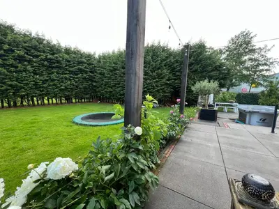 a garden with flowers around a wooden pole at Paauwze in Rijnsburg