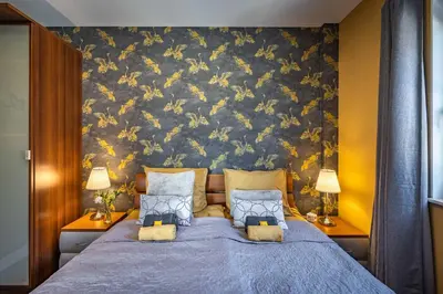 a bedroom with a blue bed with a floral wall at De Heerlijkheid Hensbroek in Hensbroek