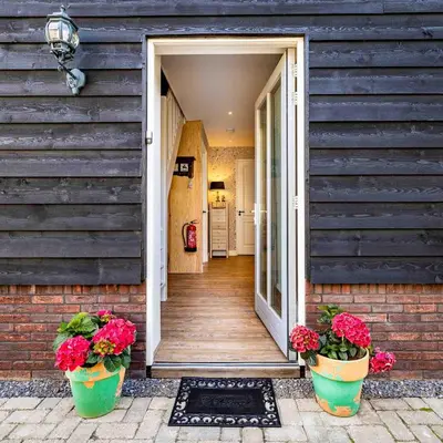 a porch of a house with two potted flowers at De Heerlijkheid Hensbroek in Hensbroek