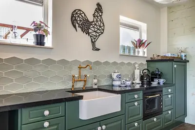a kitchen with green cabinets and a sink at De Heerlijkheid Hensbroek in Hensbroek