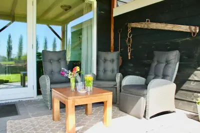 a patio with chairs and a table on a porch at De Heerlijkheid Hensbroek in Hensbroek