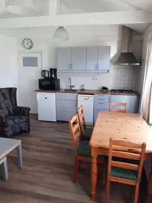 a kitchen with a wooden table and a table and chairs at Bakker2 in Groet