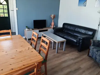 a living room with a table and a couch at Bakker2 in Groet