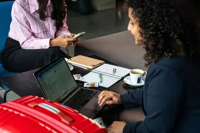 a woman sitting at a desk with a laptop computer at Moxy Utrecht in Utrecht