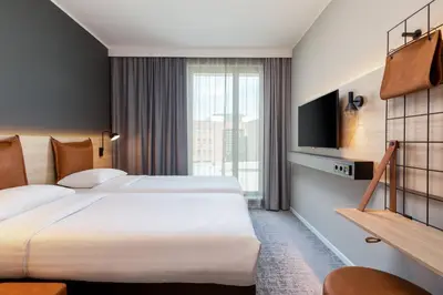 a hotel room with two beds and a tv at Moxy Utrecht in Utrecht