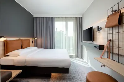 a hotel room with a bed and a large window at Moxy Utrecht in Utrecht